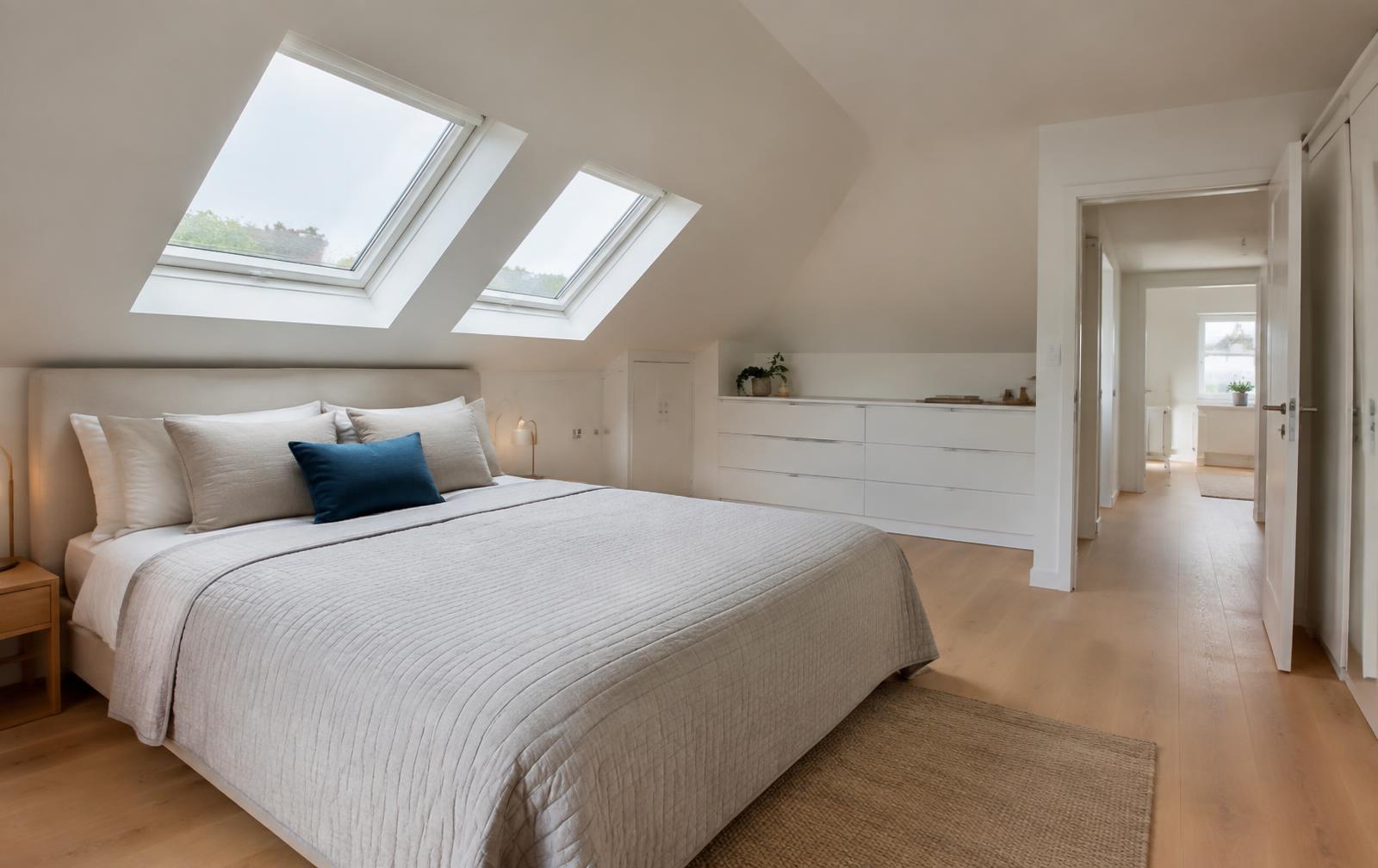 Finished attic bedroom with sloping ceilings, rooflights and oak floor